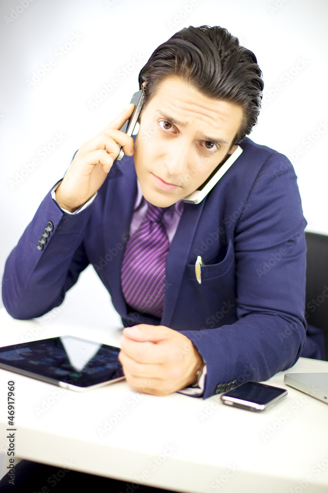 Young businessman talking with two cell phones Young businessman talking with two cell phones