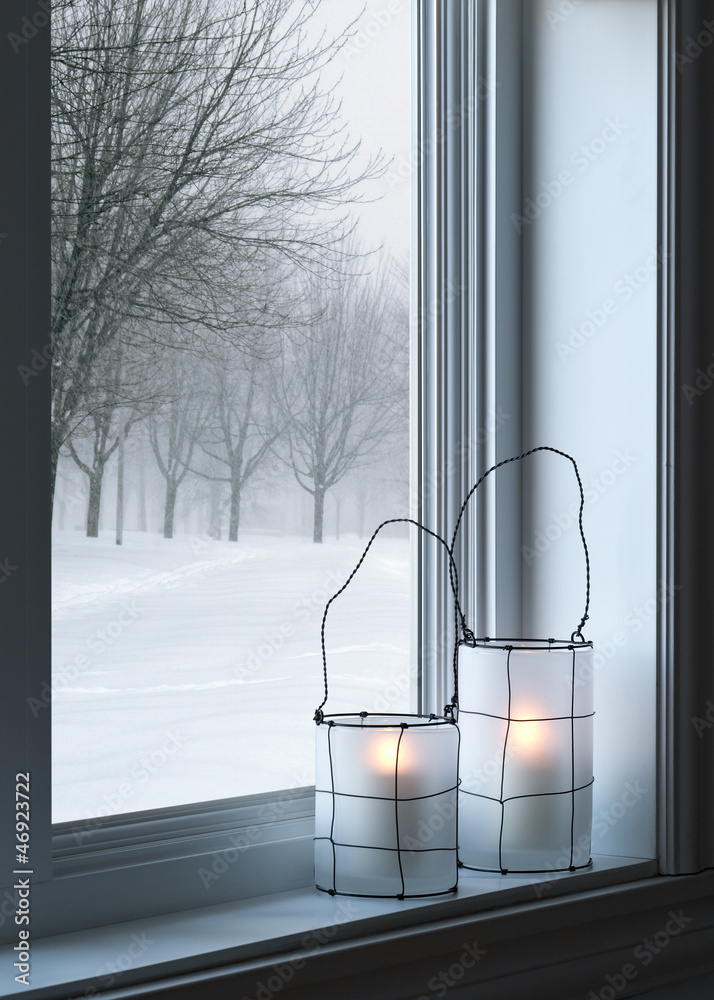 Obraz premium Cozy lanterns and winter landscape seen through the window
