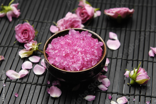 Pink herbal salt with rose petals and stones on mat