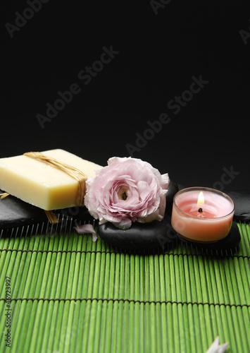 Candle and rose with pebble stones with green mat