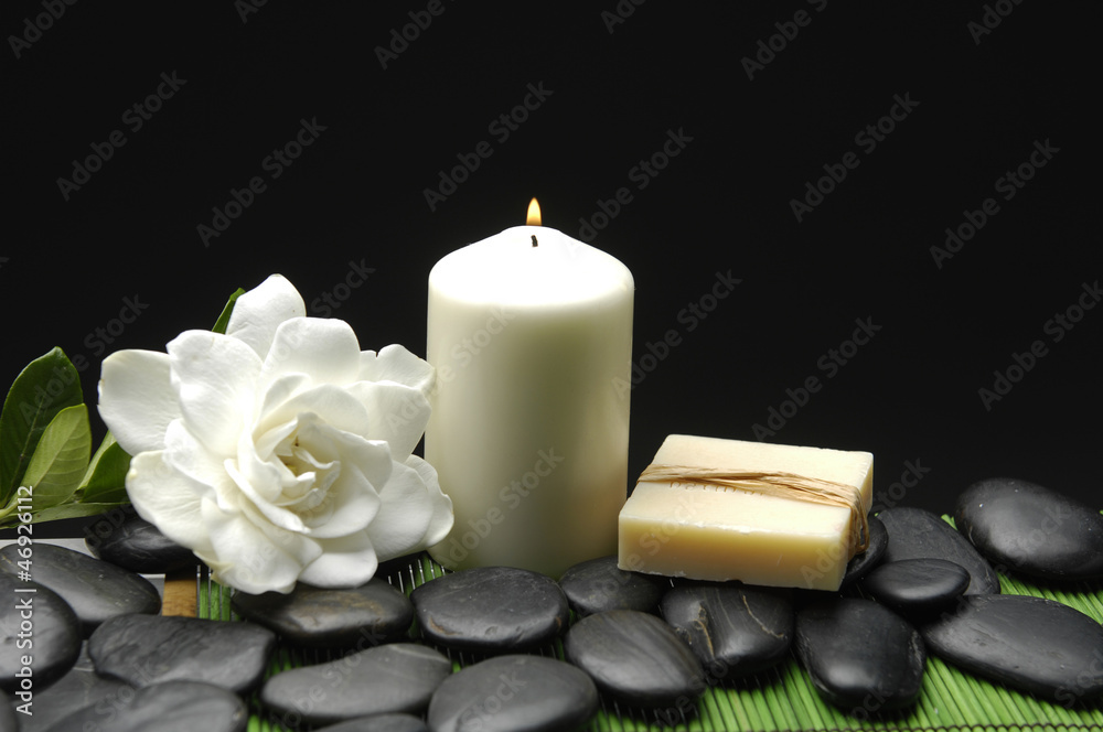 Gardenia and stones with candle and soap on green mat