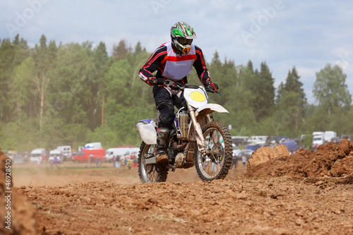 Young man wearing in helmet on dirt motorcycle jumps