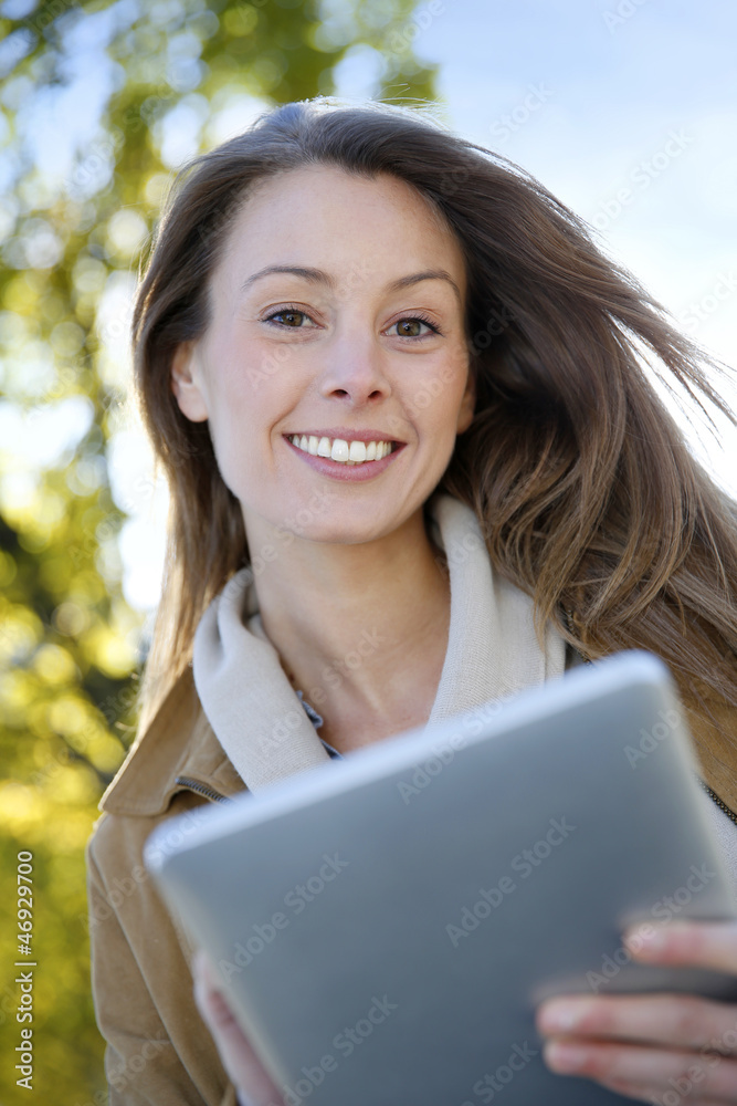 Fototapeta premium Beautiful girl using digital tablet outside