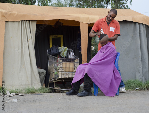 Small African Haircut Barber Business man cutting hair photo