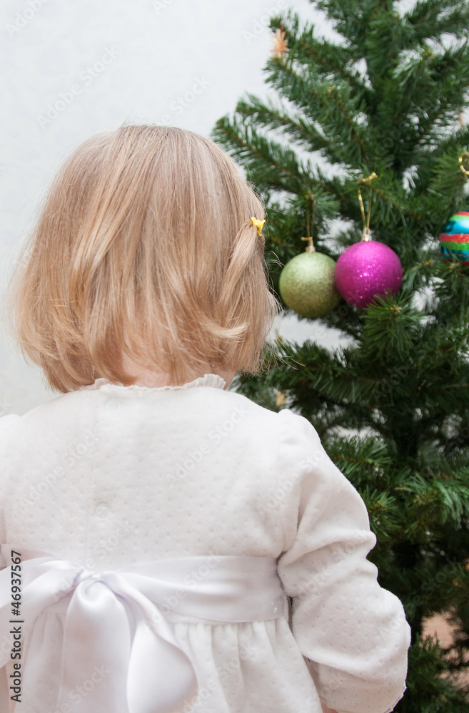 Little girl decorating a Christmas tree