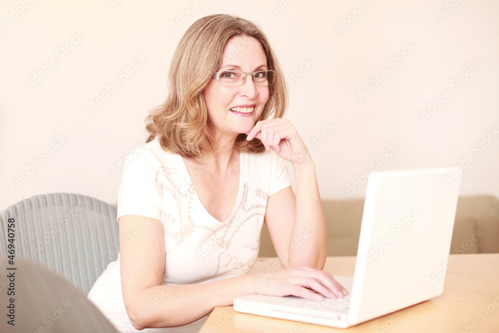 Reife Frau tippt auf ihrem Laptop Reife Frau tippt auf ihrem Laptop