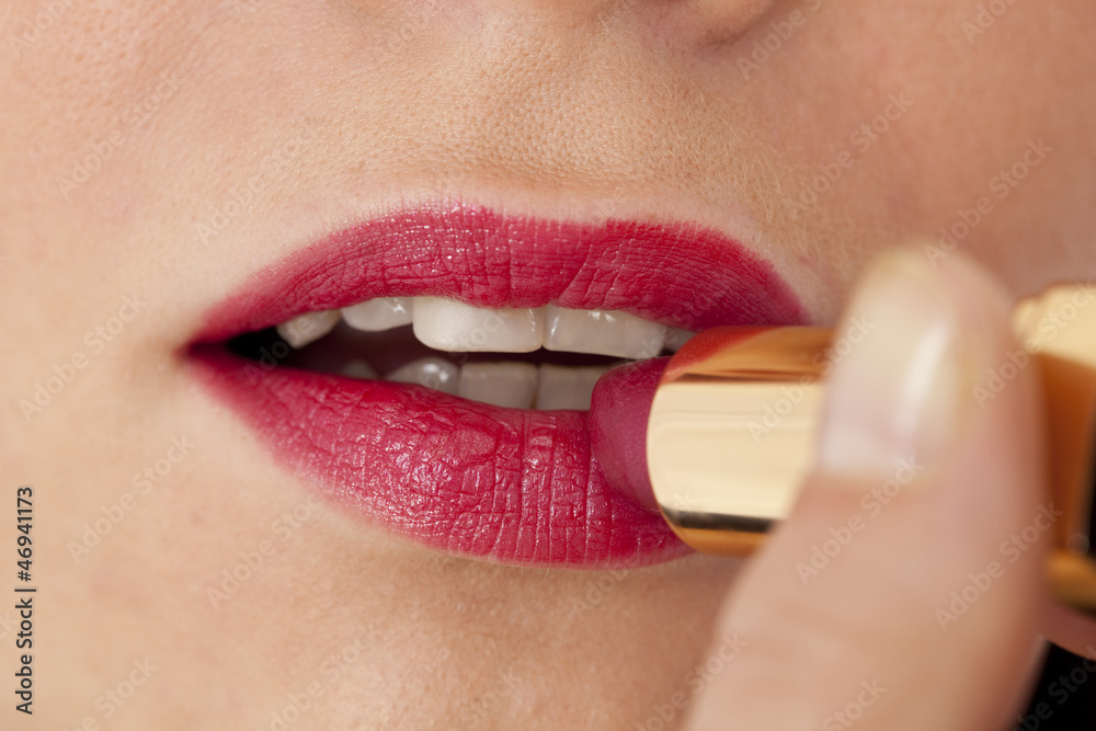 Naklejka premium Applying lipstick
