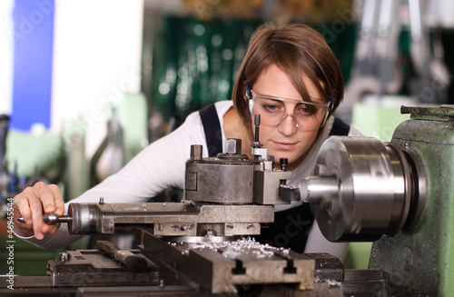 Junge Frau an der Drehmaschine