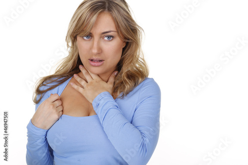 Junge Frau fasst sich an den Hals bei Halsschmerzen