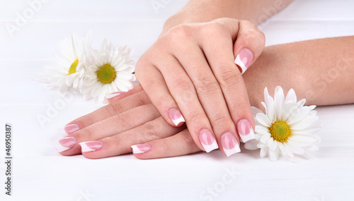 Woman hands with french manicure and flowers