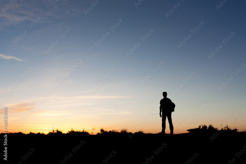 Silhouette of a mountaineer enjoying the sunset view