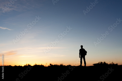 Silhouette of a mountaineer enjoying the sunset view © dunga