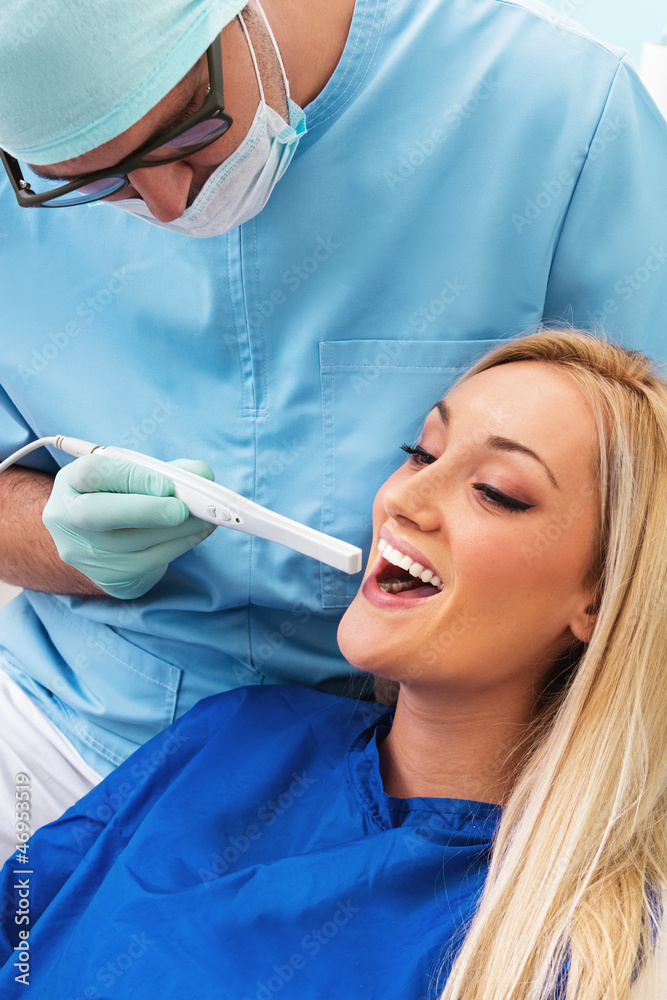 Dentist examines teeth of the patient with teeth-camera Dentist examines teeth of the patient with teeth-camera