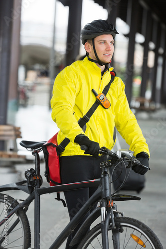 Young Man With Bicycle And Bag Looking Away