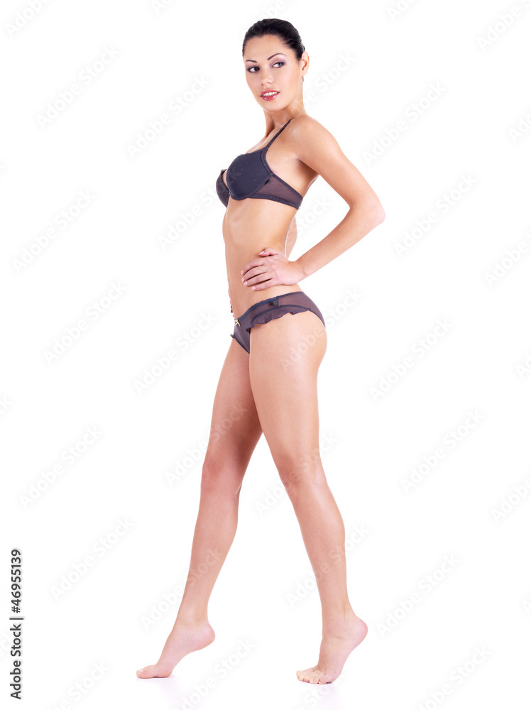 Sexy young woman in a bikini standing on white. Sexy young woman in a bikini standing on white.