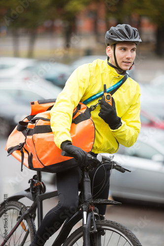 Male Cyclist With Courier Bag Using Walkie-Talkie