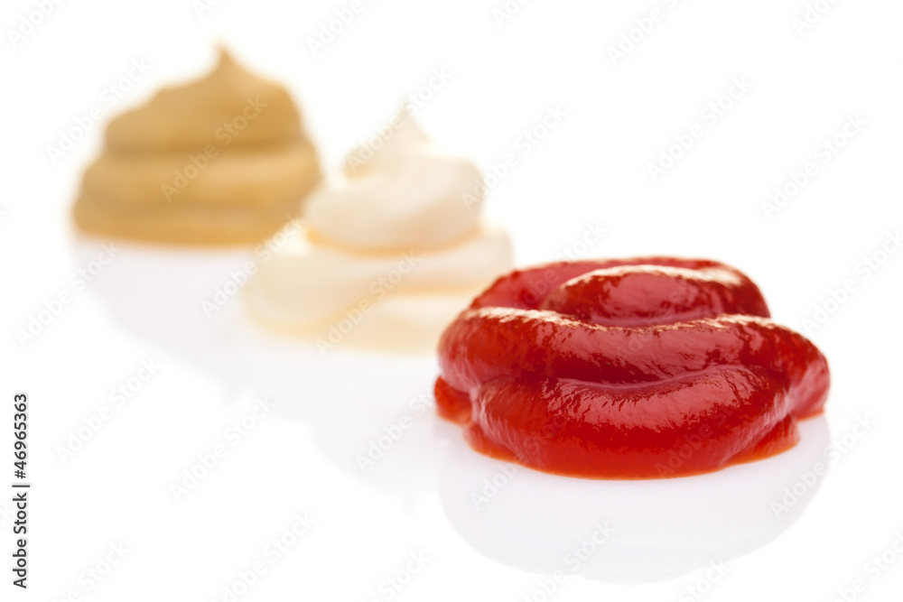 Ketchup, Mayonnaise und Senf diagonal auf weißem Hintergrund Ketchup, Mayonnaise und Senf diagonal auf weißem Hintergrund