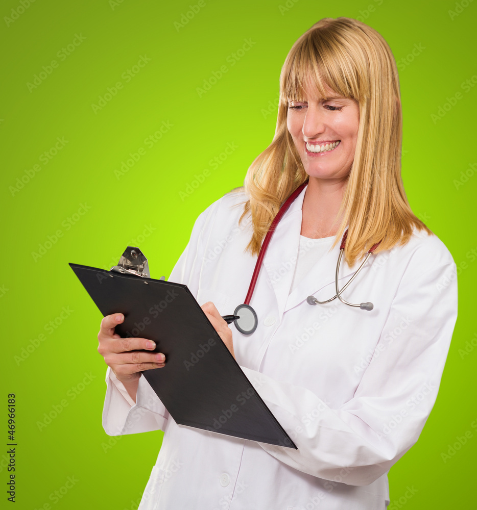 Portrait Of Happy Doctor Writing On Clipboard Portrait Of Happy Doctor Writing On Clipboard