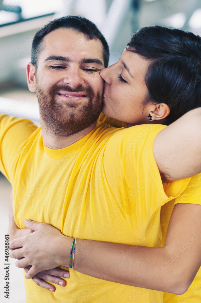 Young couple embracing and kissing at the gym.