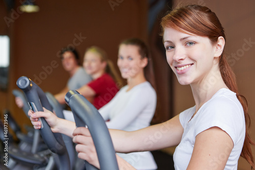 Gruppe trainiert im Fitnesscenter am Crosstrainer