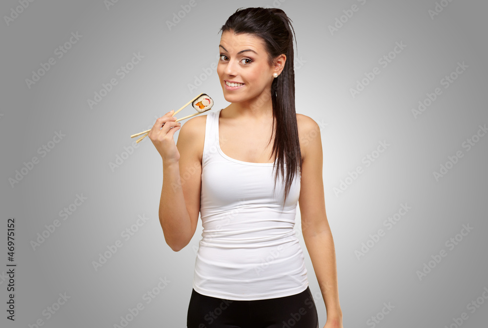 Young girl Holding Sushi Roll with chopsticks Young girl Holding Sushi Roll with chopsticks