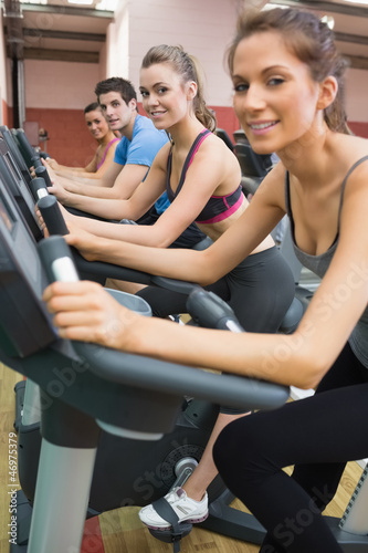Three woman and one man on exercise bikes
