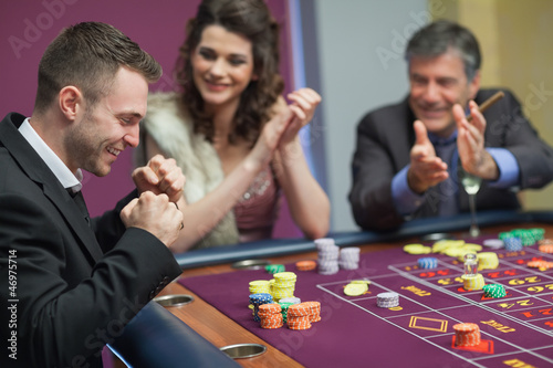 Billede på lærred People cheering man at craps game