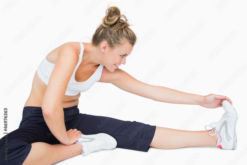 Woman sitting while stretching leg Woman sitting while stretching leg
