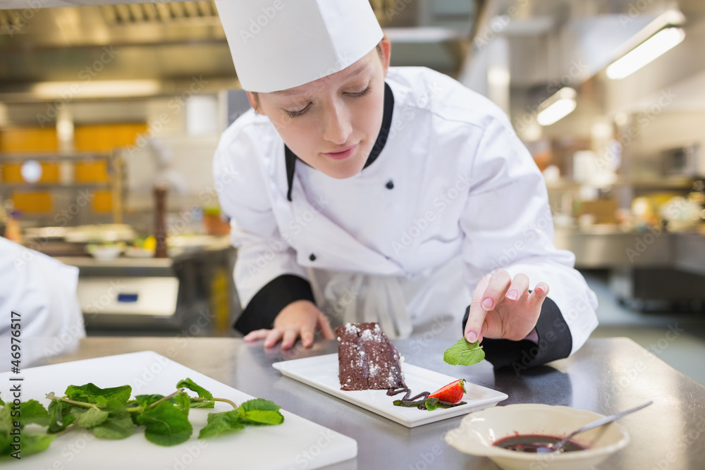 Chef putting mint with her chocolate cake Chef putting mint with her chocolate cake