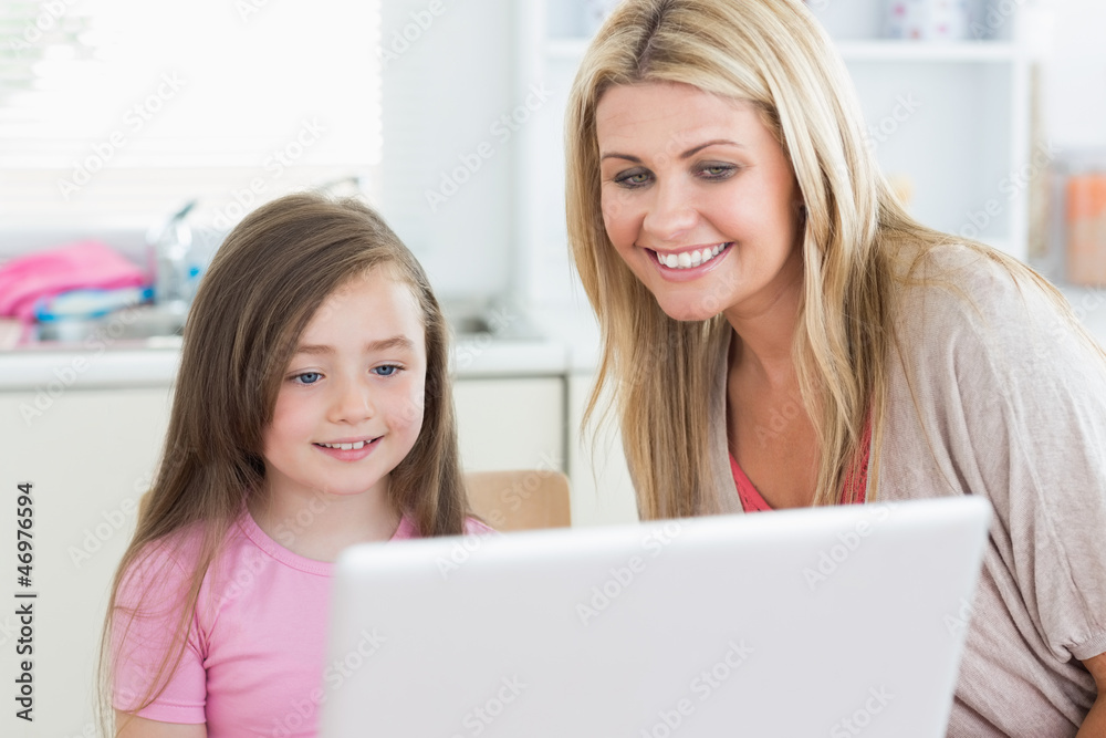 Woman and girl looking at the laptop monitor Woman and girl looking at the laptop monitor