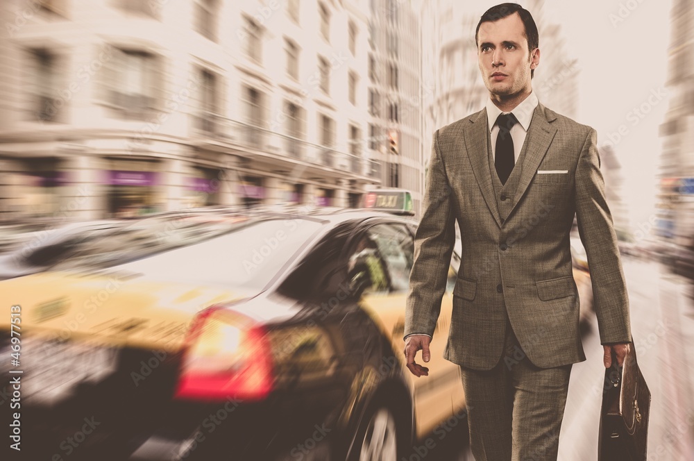 Man in classic grey suit with briefcase walking outdoors Man in classic grey suit with briefcase walking outdoors