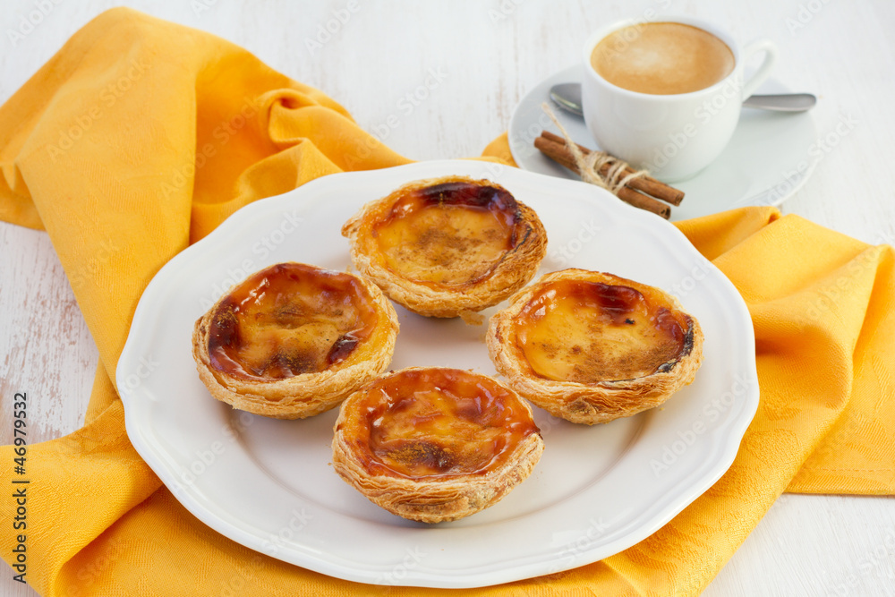 Portuguese pastries on the plate with a cup of coffee