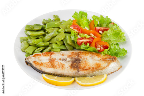 fried fish with beans and salad on the plate on white background