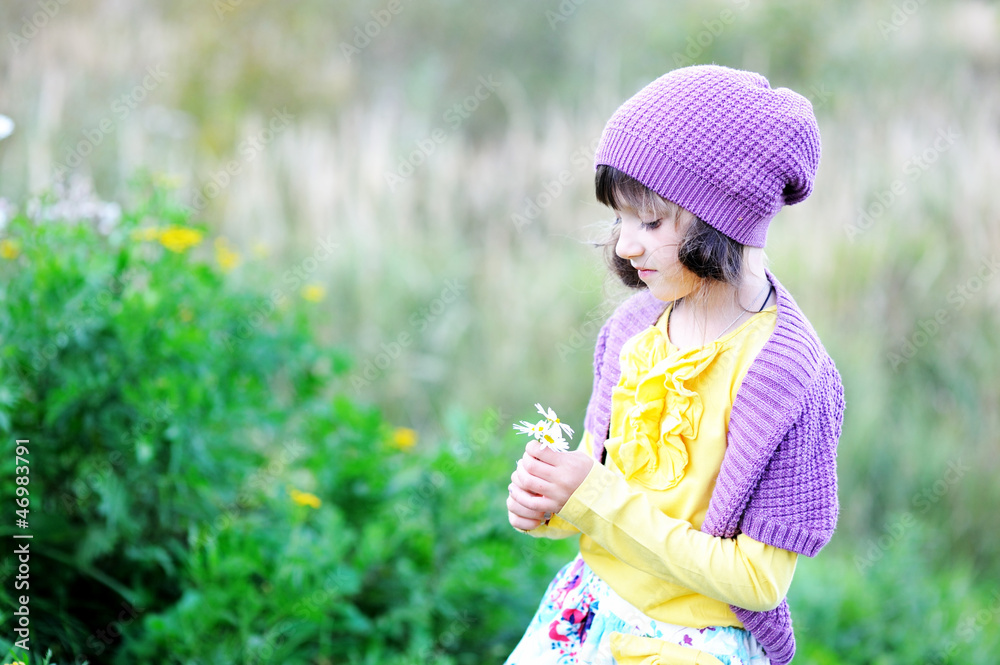 Outdoor portrait of little girl with flowers