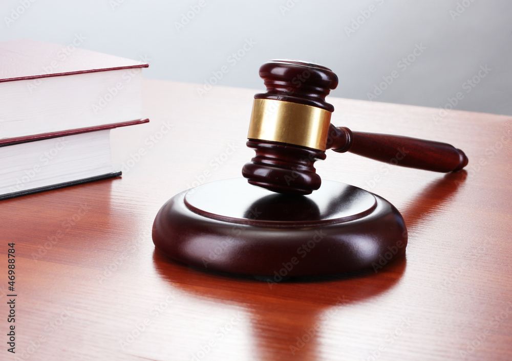 gavel and books on wooden table on gray background
