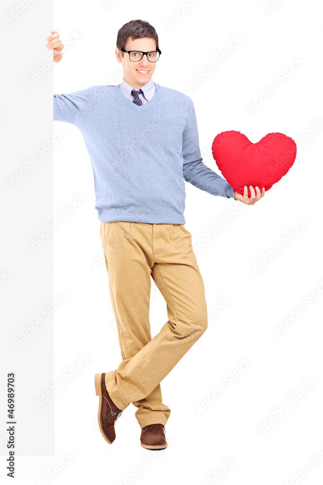 Full length portrait of a young male holding a panel and red hea Full length portrait of a young male holding a panel and red hea
