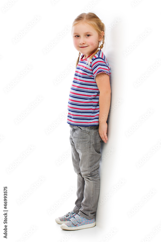 Little girl leaning against a white wall. Little girl leaning against a white wall.