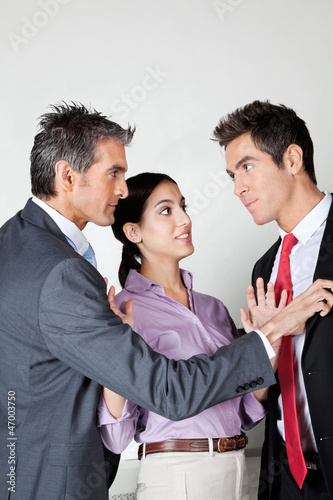 Businesswoman Acting As Peacemaker Between Colleagues