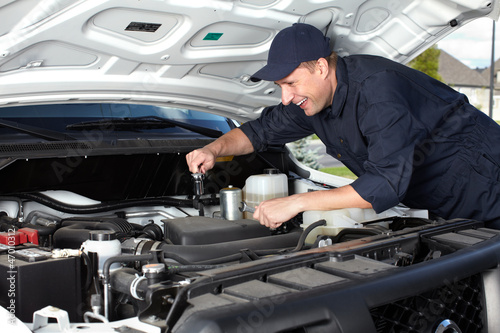 Car mechanic working in auto repair service. © Kurhan