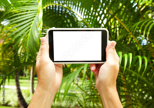 Woman with a smartphone in tropical garden.