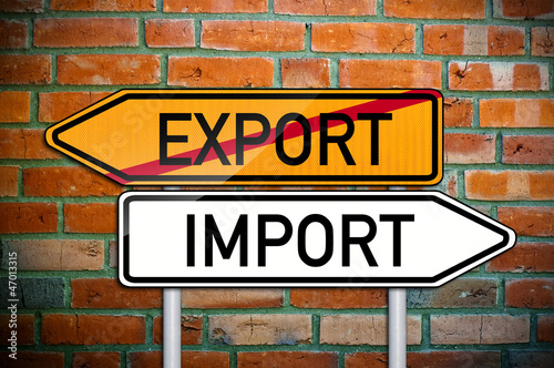 Wegweiser vor Ziegelsteinwand mit Export und Import