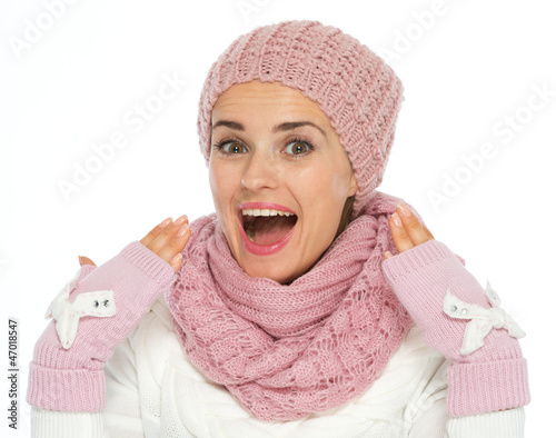 Surprised young woman in knit scarf, hat and mittens