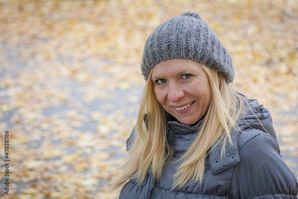 Blonde Frau vor Herbsthintergrund
