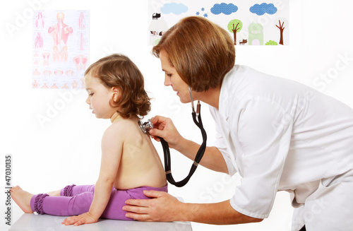 Eine Kinderärztin hört ein Mädchen mit dem Stethoskop ab