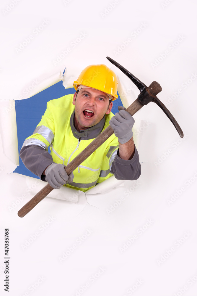 Construction worker breaking through a barrier with a pickaxe Construction worker breaking through a barrier with a pickaxe