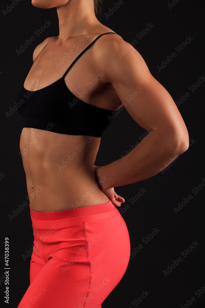 Fototapeta premium muscular female body against black background.