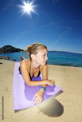 Young woman, sunbathing on a beach