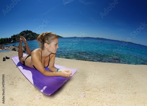 Young woman, sunbathing on a beach
