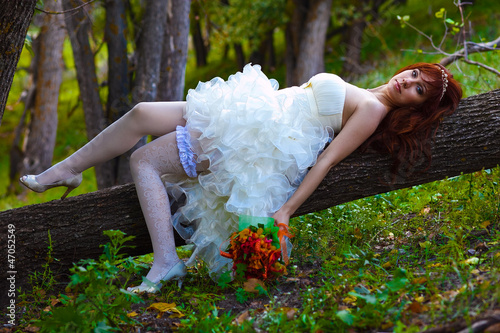 Bride red haired woman in a white dress with sexy legs with gart photo