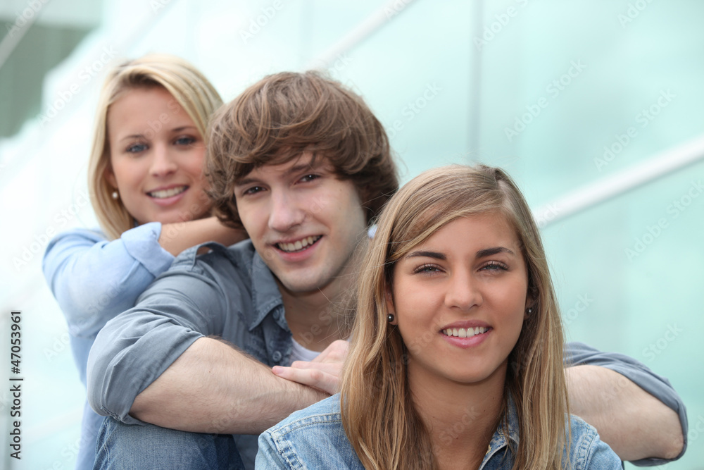 three students sitting on stairs three students sitting on stairs